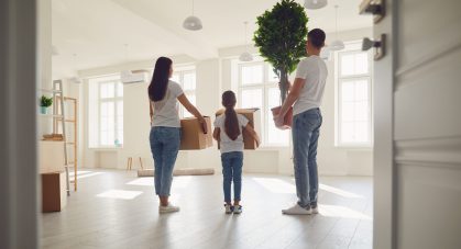 Happy,Family,With,Children,Moving,With,Boxes,In,A,New